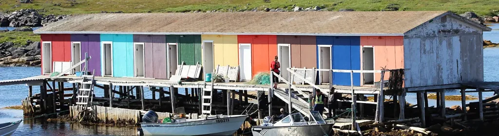 Colourful fishing building on stilts with motorboats tied up to it