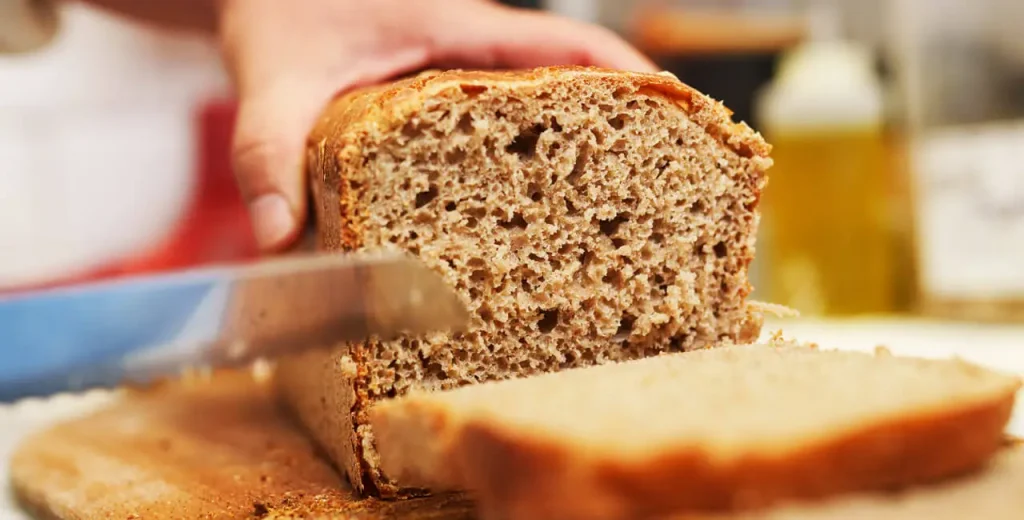 Cutting fresh bread into slices on a cutting board