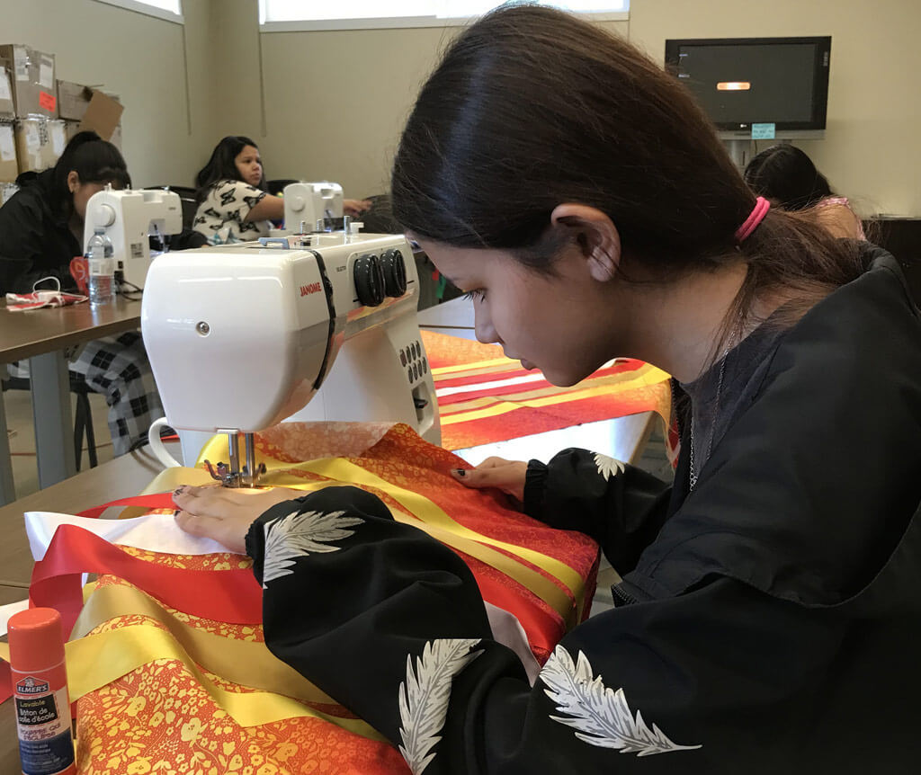 young girl at a sewing machine making Traditional clothing