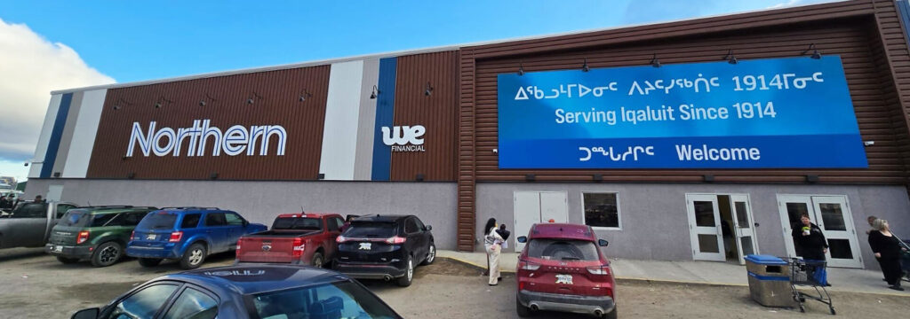 Front of the new Northern Store with the Northern sign, We Financial. Various cars and people outside